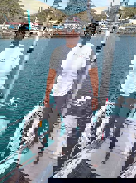 posed shot of woman standing on sailing yacht going into dock