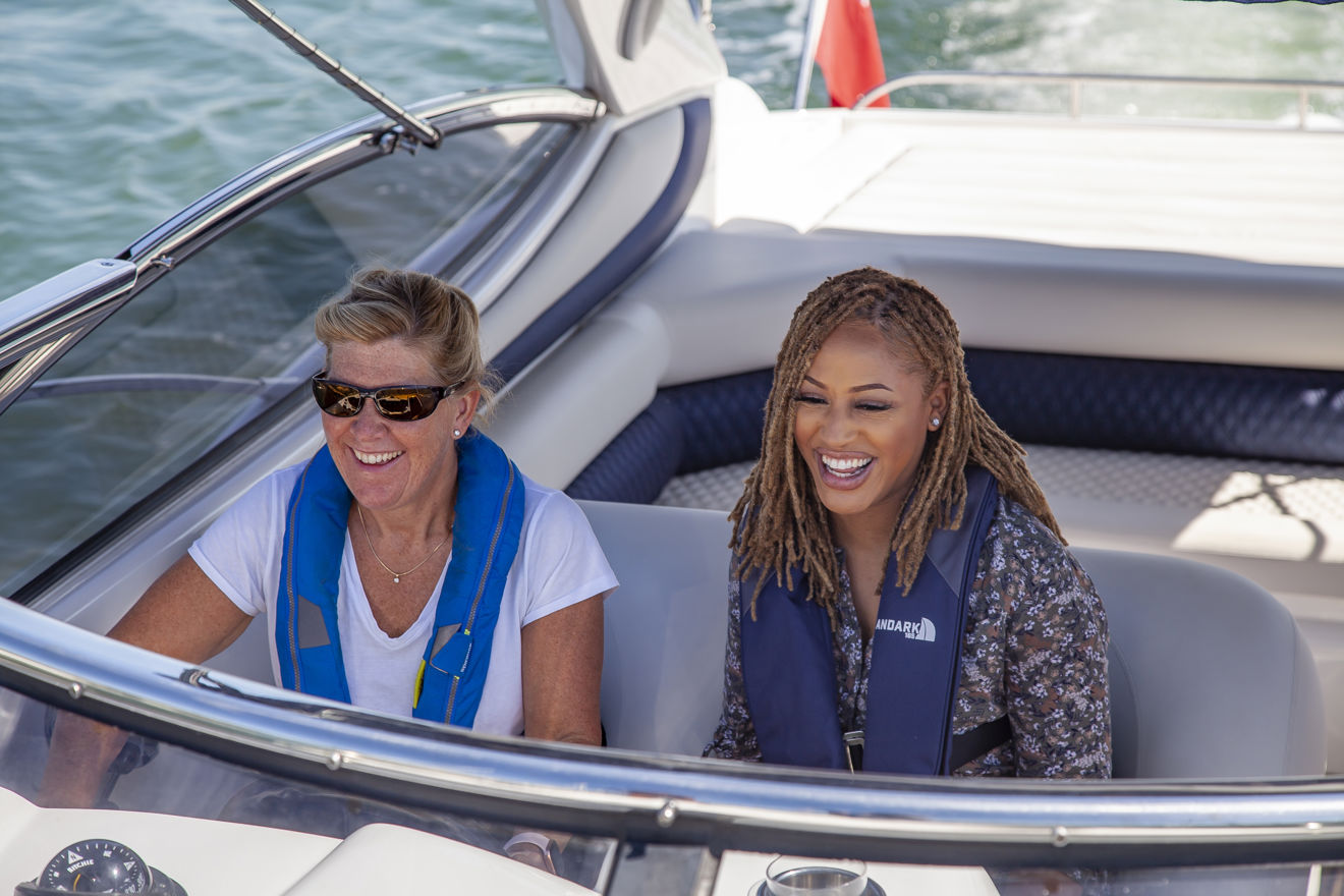 Birdseye view of two women wearing lifejackets on a powerboat