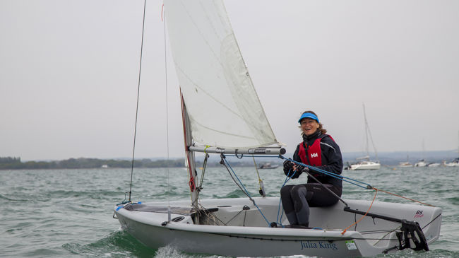 wide shot of a woman steering an RS feva sailing dinghy