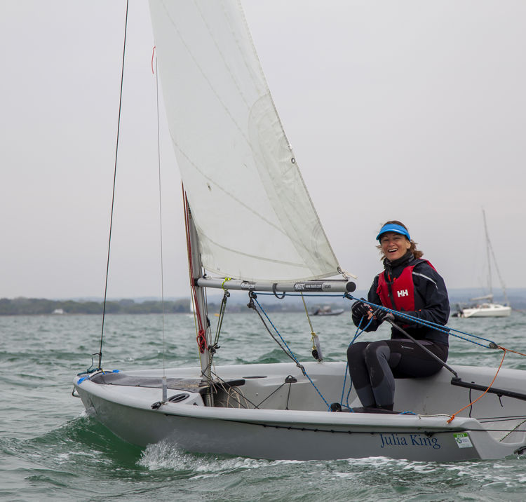 wide shot of a woman steering an RS feva sailing dinghy