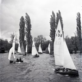 Black and white image of wooden dinghies preparing for a race