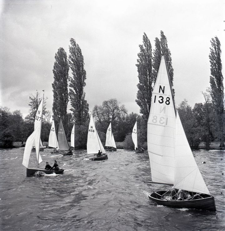 Black and white image of wooden dinghies preparing for a race
