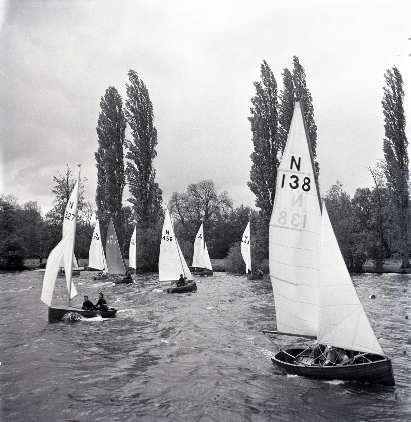 Black and white image of wooden dinghies preparing for a race