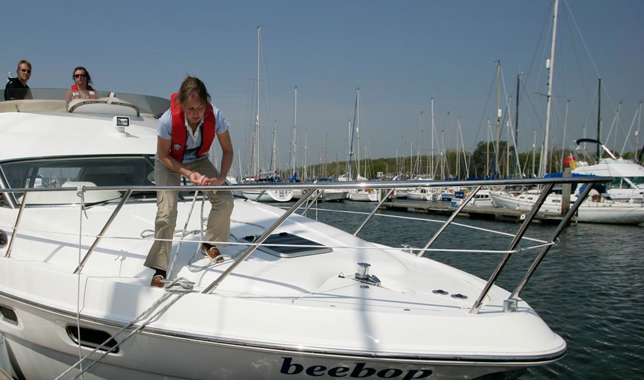 woman on boat deck tying a rope