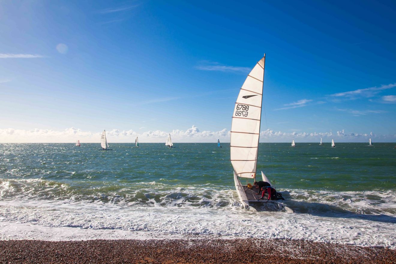 Long shot of catamaran on water with beach