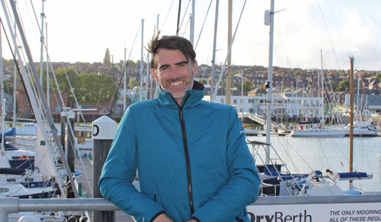 Giles Ferrier leaning on some railings looking at the camera smiling