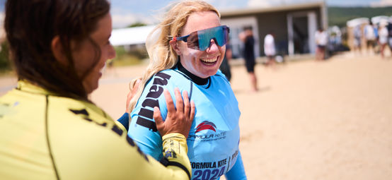 	An image of Aldridge laughing at the Formula Kite World Championship with a women supporting her by the side