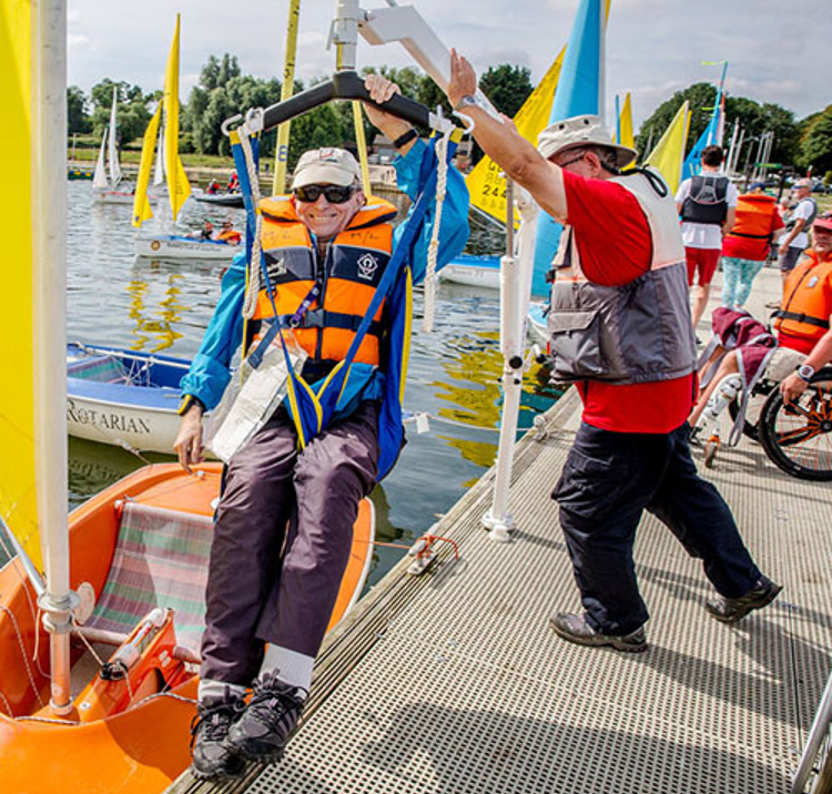 Sailability sailor being lowered into boat