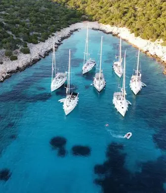 An aerial view of yachts moored in a lagoon on the coast of Aegina, Greece with a background of lush vegetation