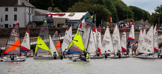 Multitude of youth and junior boats with colourful sails launching from the beach at Dale for the Welsh Club Championships 2026.