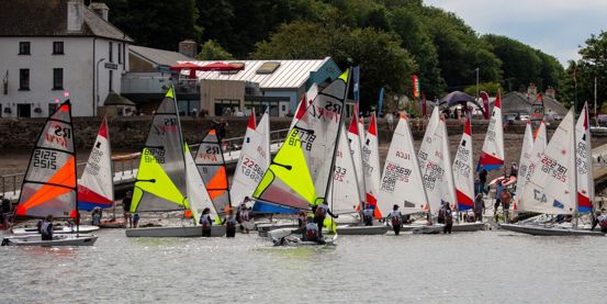 Multitude of youth and junior boats with colourful sails launching from the beach at Dale for the Welsh Club Championships 2026.