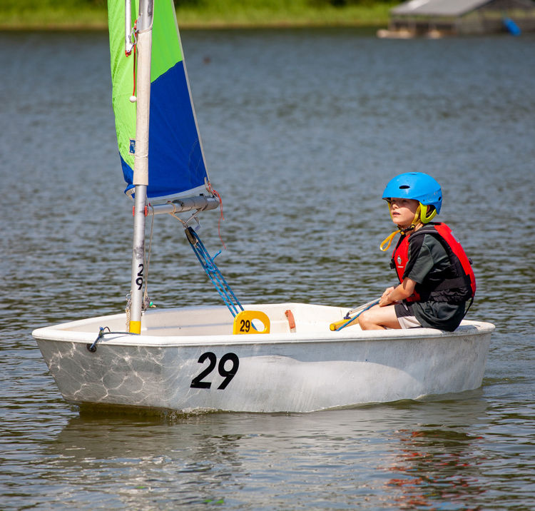 Long shot of child on sailboat