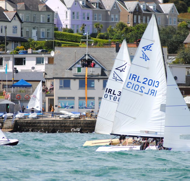 A group of yachts racing past the club house
