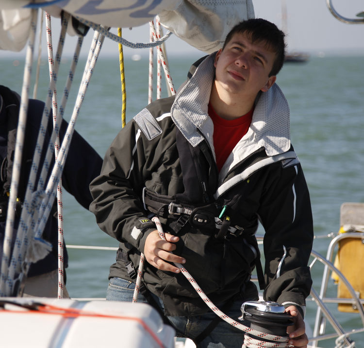 young man on a sail cruising course