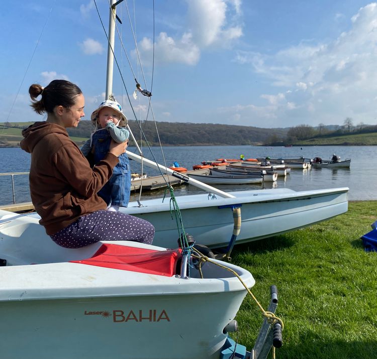 Ella Williams sat on the side of a dinghy holding her baby