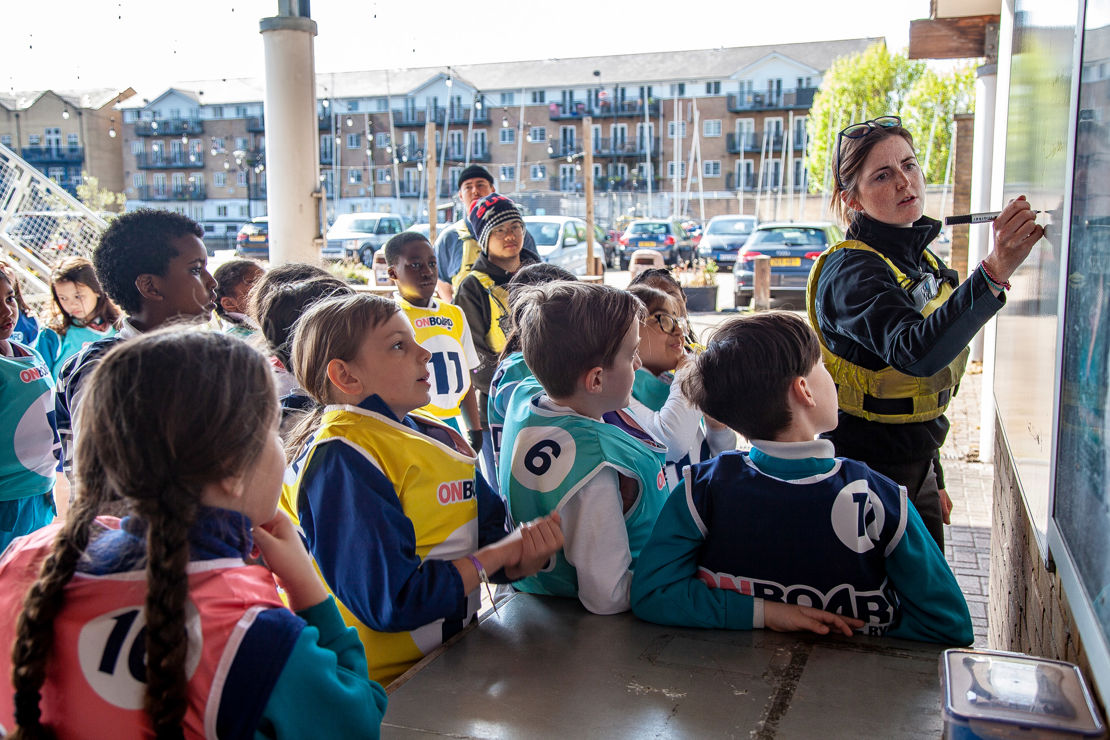 Mid shot of group of children being taught using a whiteboard