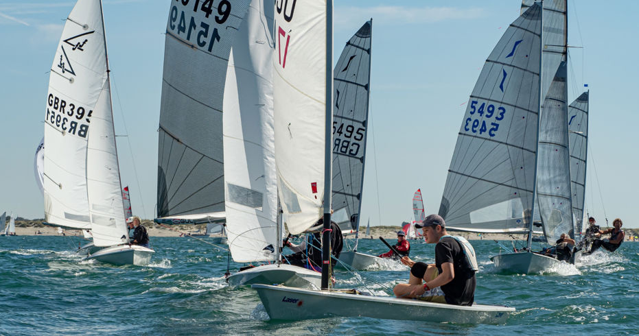 Dinghies racing across blue water during multi class