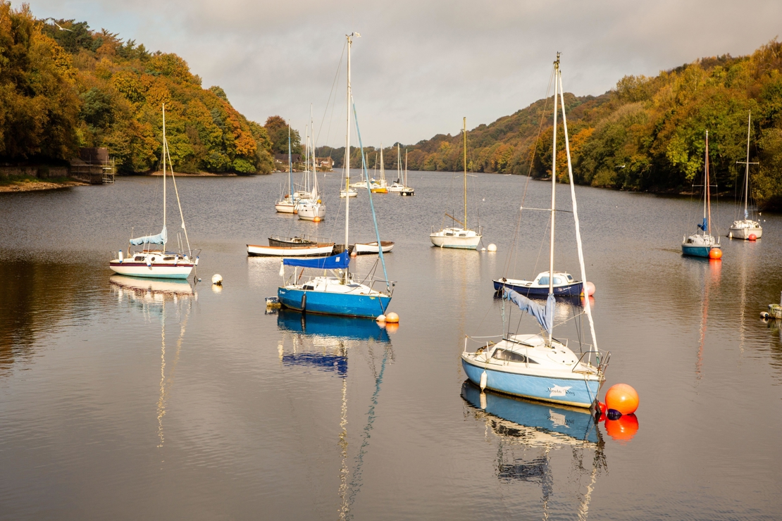 wide shot of sailing boats moored on a river