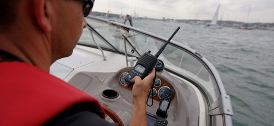 Man using VHF radio while steering boat