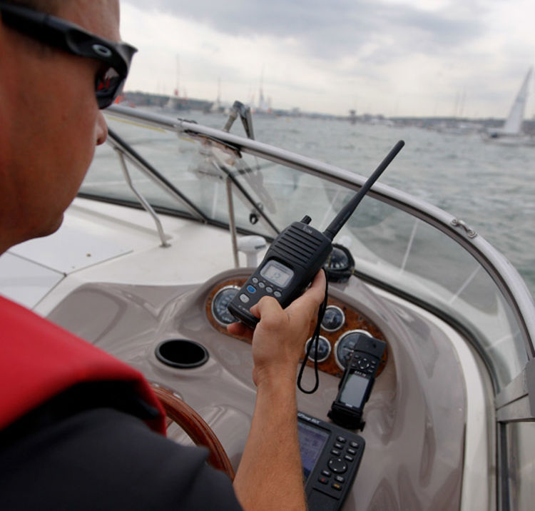 Man using VHF radio while steering boat