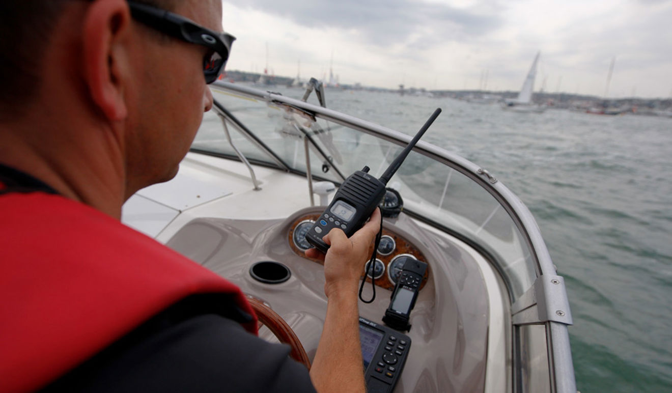 Man using VHF radio while steering boat