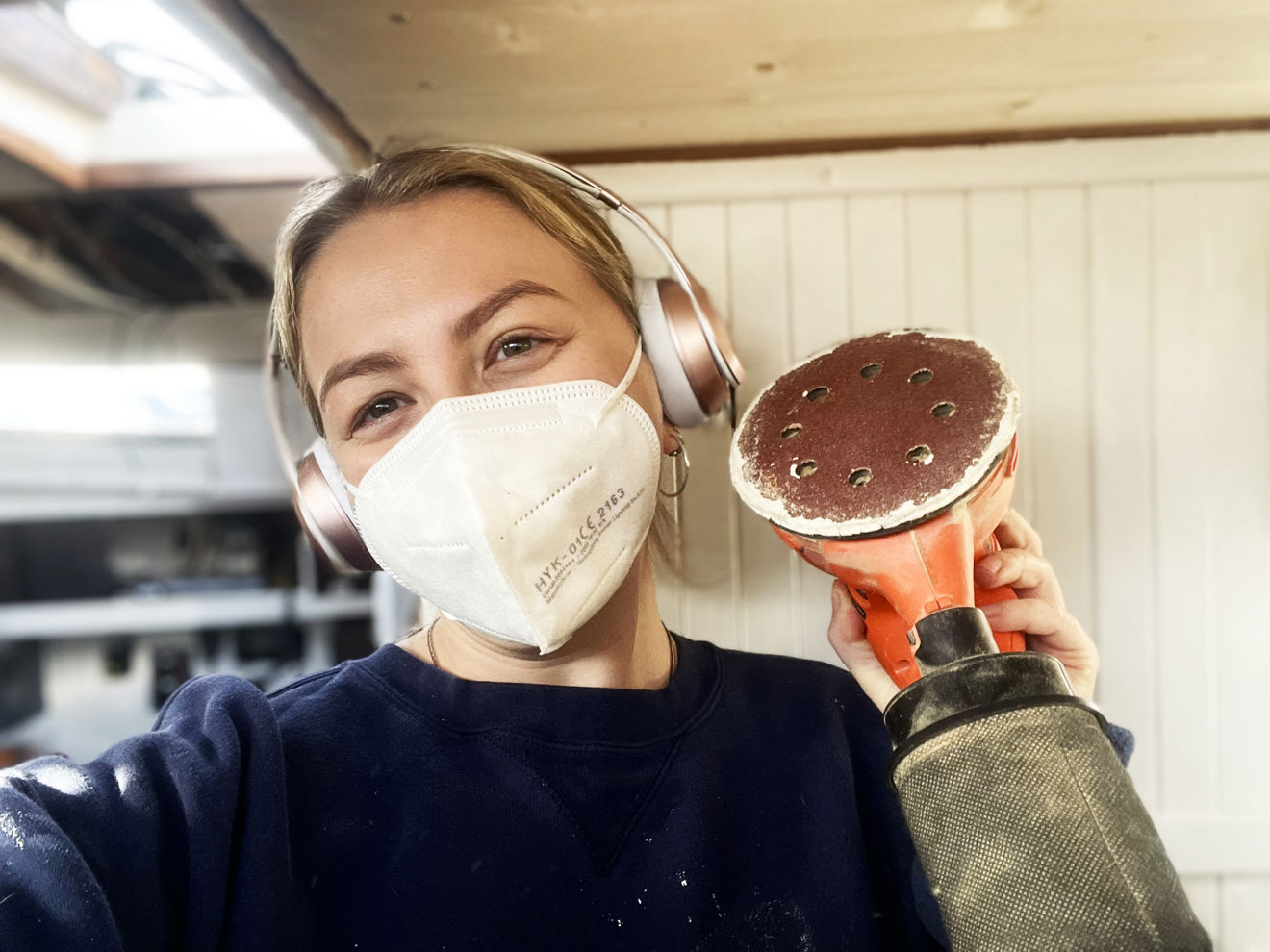 lady holding a sander inside a boat