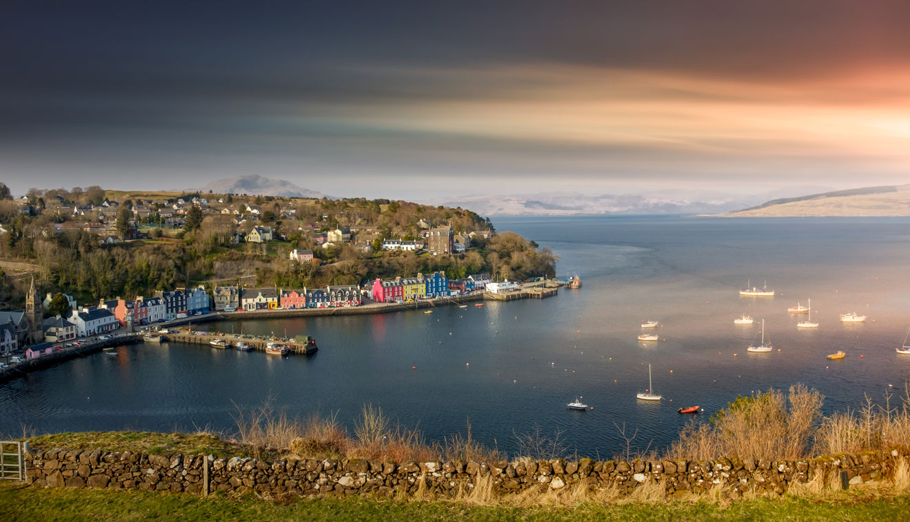 An image of wide shot of sunrise over Tobermory Bay in Scotland