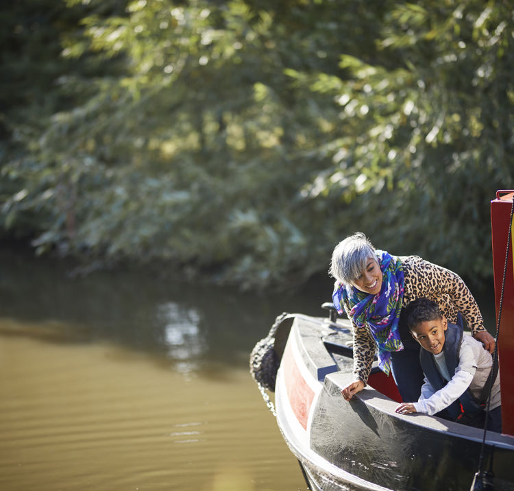 Mother and sun looking over the edge of their canal boat