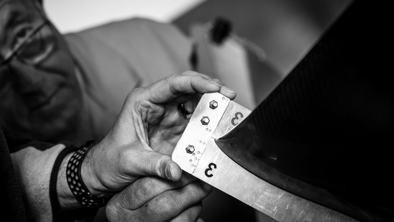 	An image of person using the scale to measure a piece equipment with their colleague