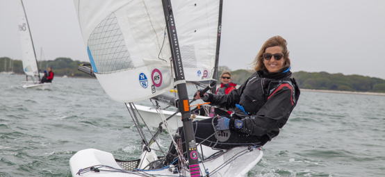 Woman on a dinghy looking to the camera and smiling