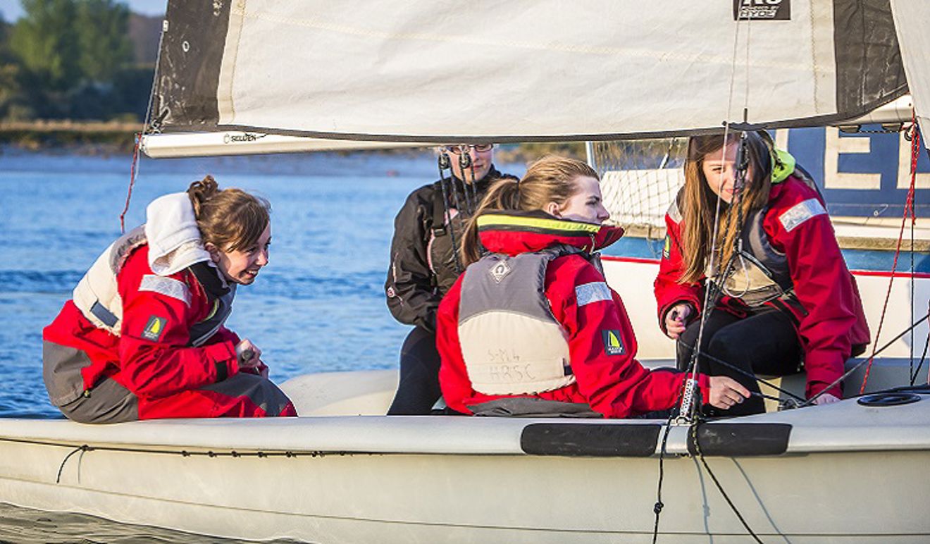 four women sailing in a dinghy