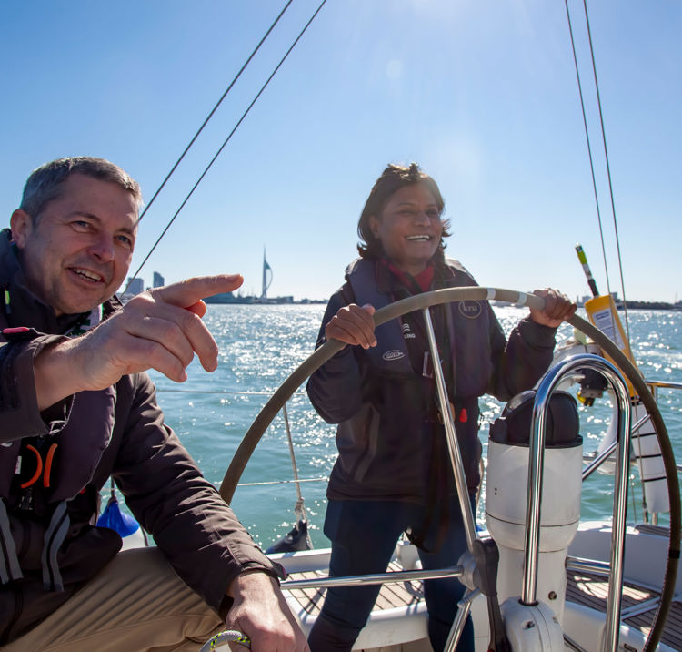 Woman steering boat with instructor