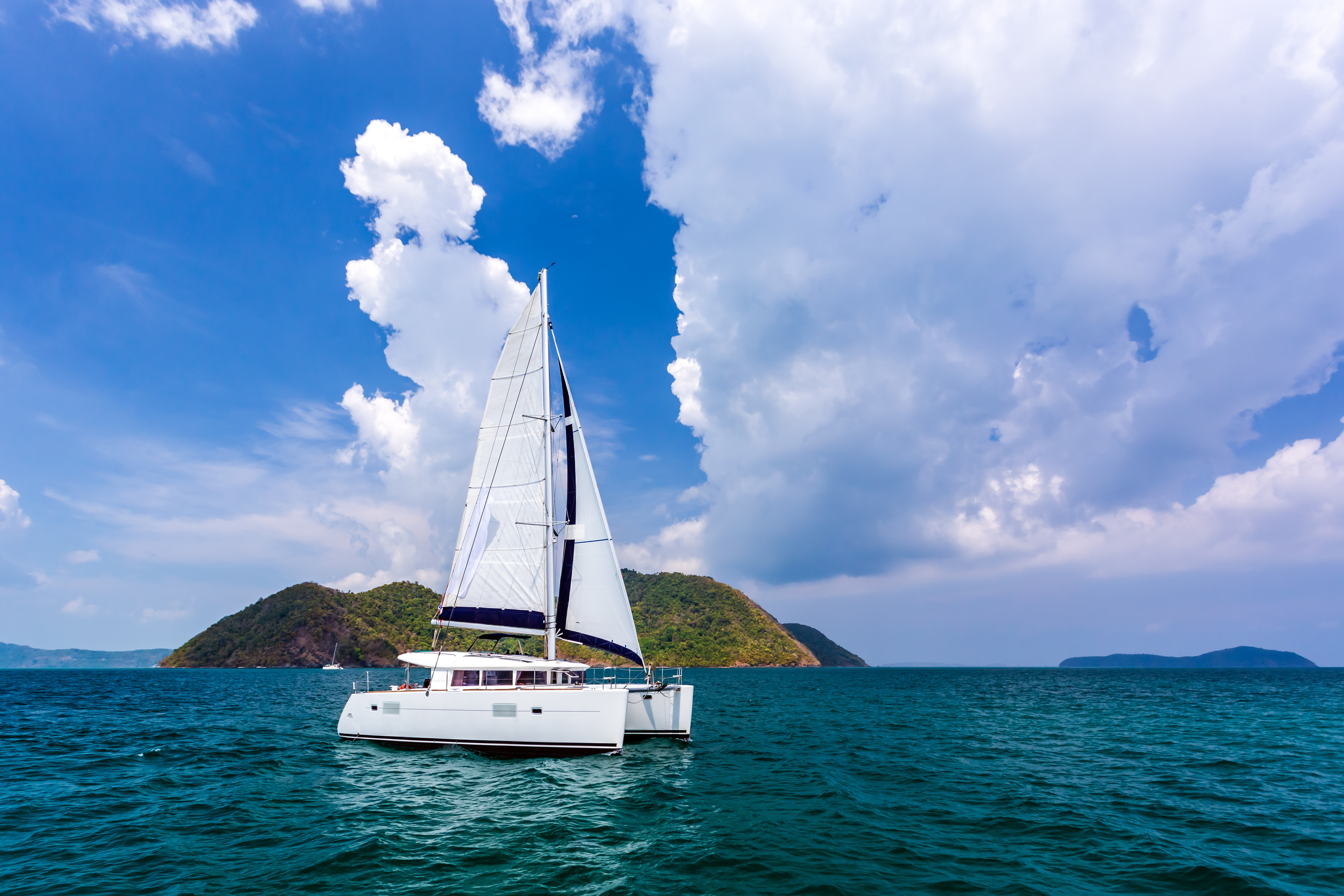 White catamaran on ripples the water in Andaman sea with blue sky and clouds at Phuket, Thailand