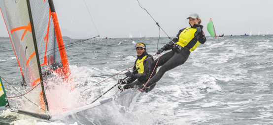 Long shot of two sailors steering a dinghy