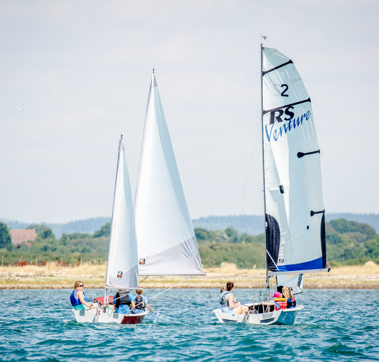 Families enjoying a summer afternoon on their dinghies