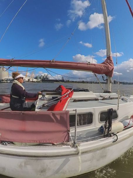 	a woman sailing a Squib on the Thames
