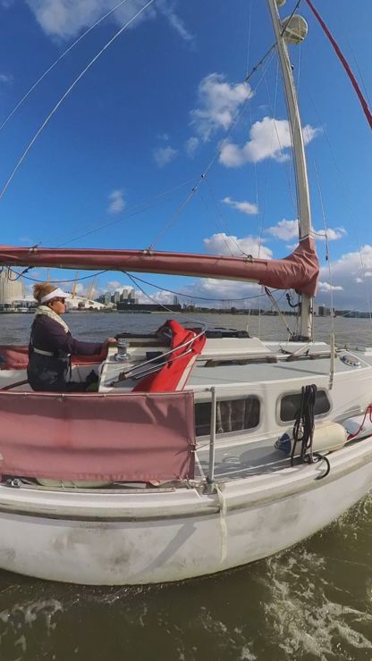 	a woman sailing a Squib on the Thames