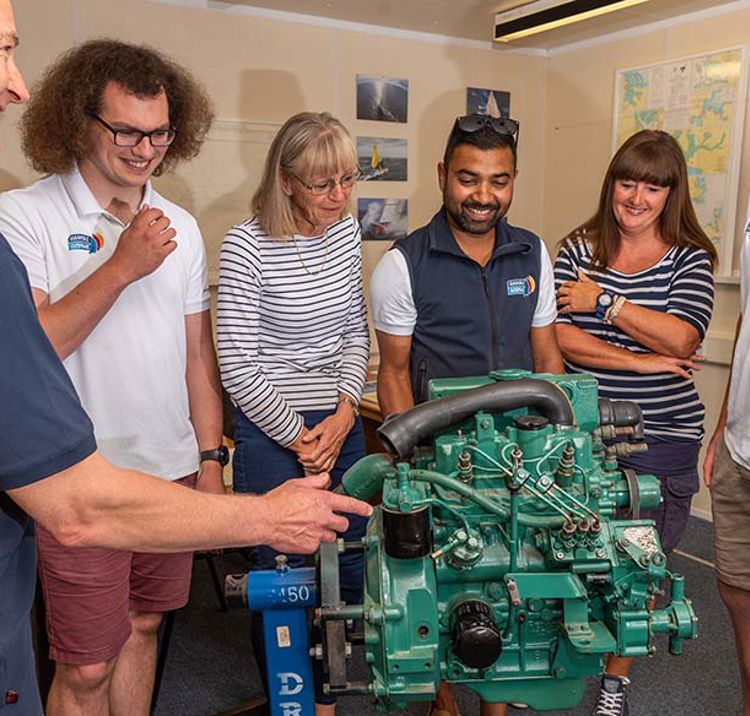 diesel engine course group of people standing around an engine