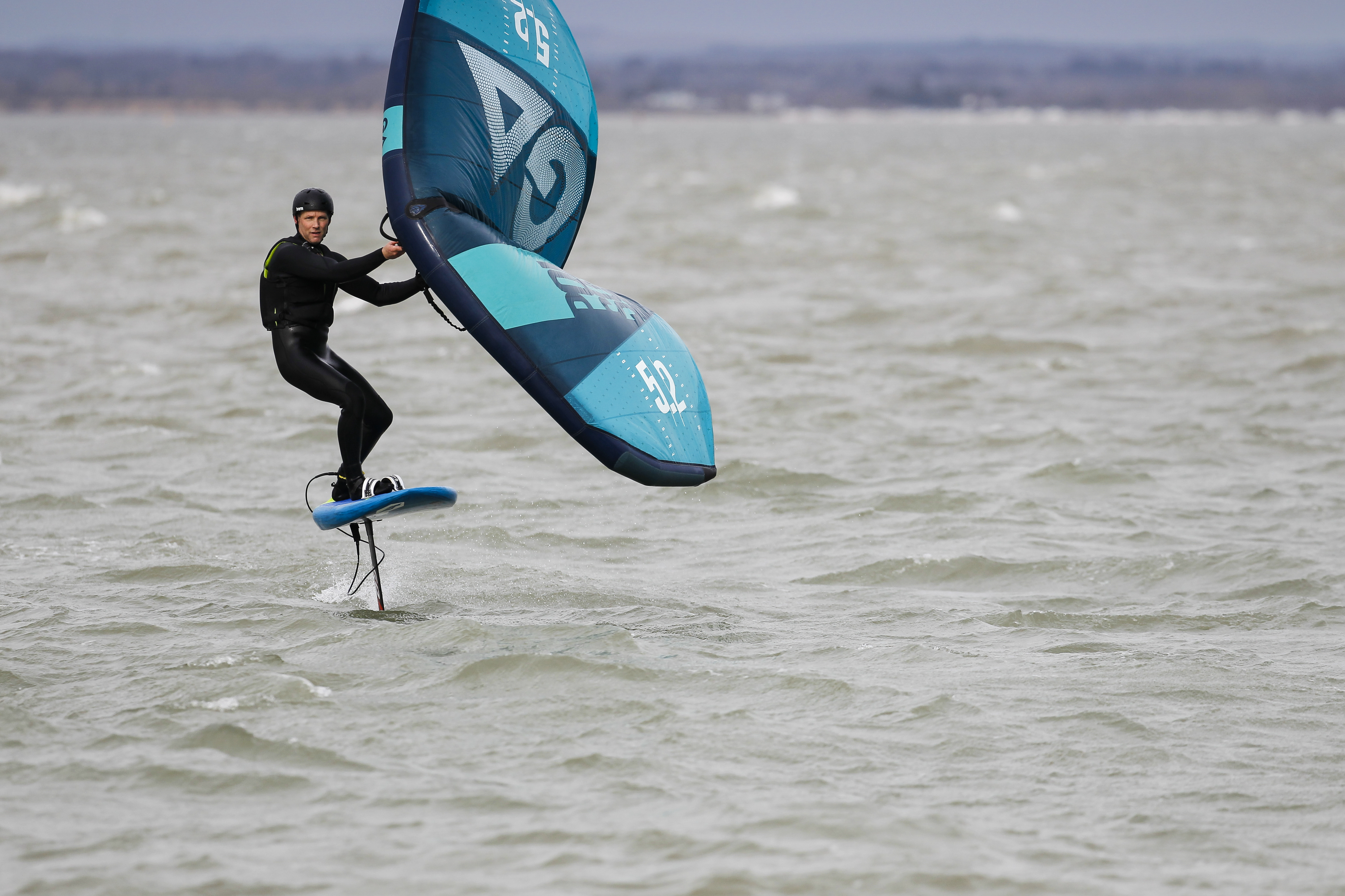 Man wingfoiling towards camera