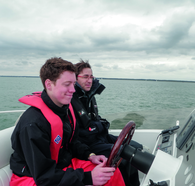 Two sailors sat at the helm of powerboat