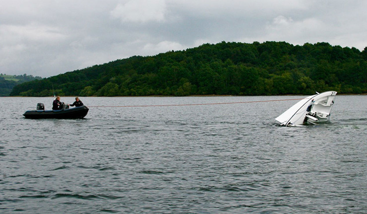 wide shot of keelboat recovery during capsize