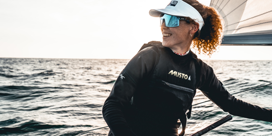 A member of the British Sailing Squad on a dinghy wearing Musto apparel