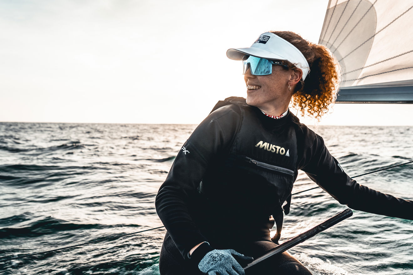 A member of the British Sailing Squad on a dinghy wearing Musto apparel
