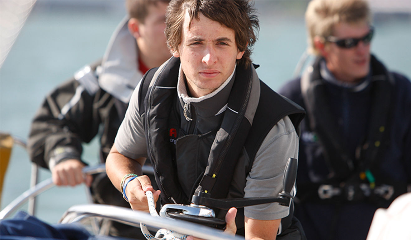 close up of man on sailing yacht doing ropework