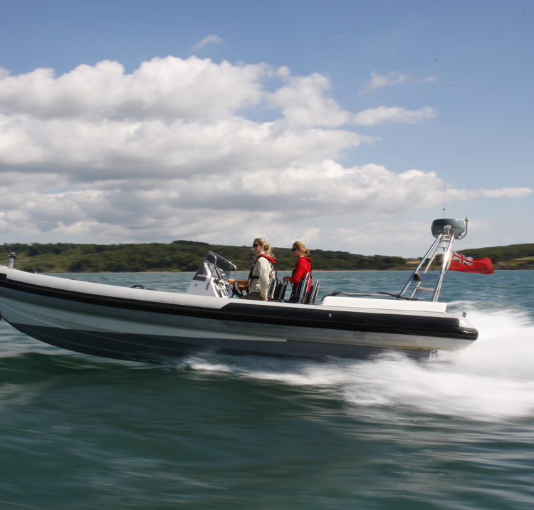 Two women and helm in fast, planing RIB