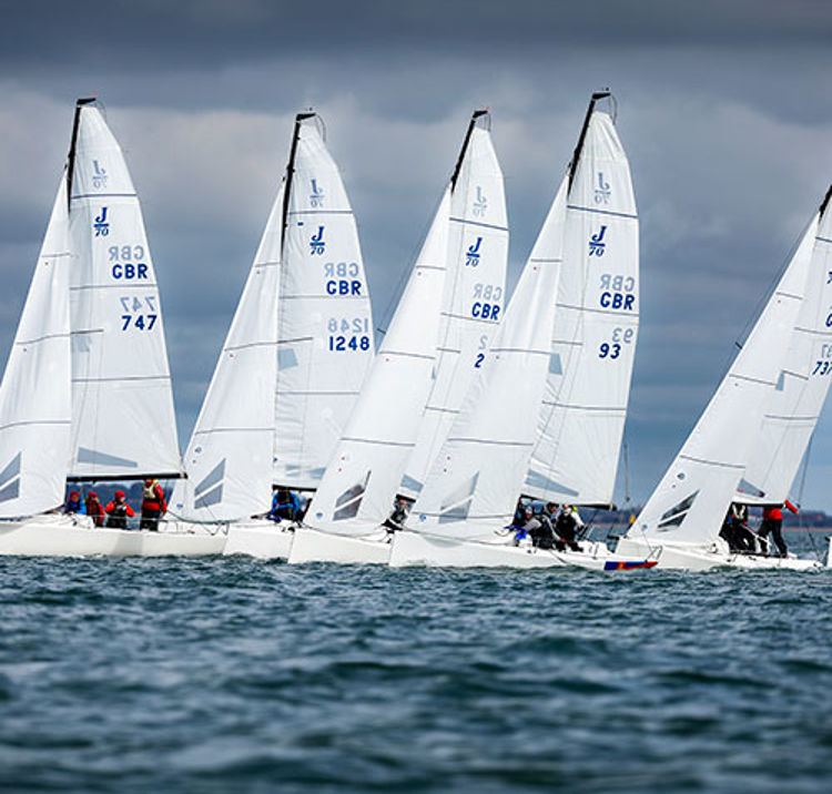 multiple keelboats sailing across the horizon
