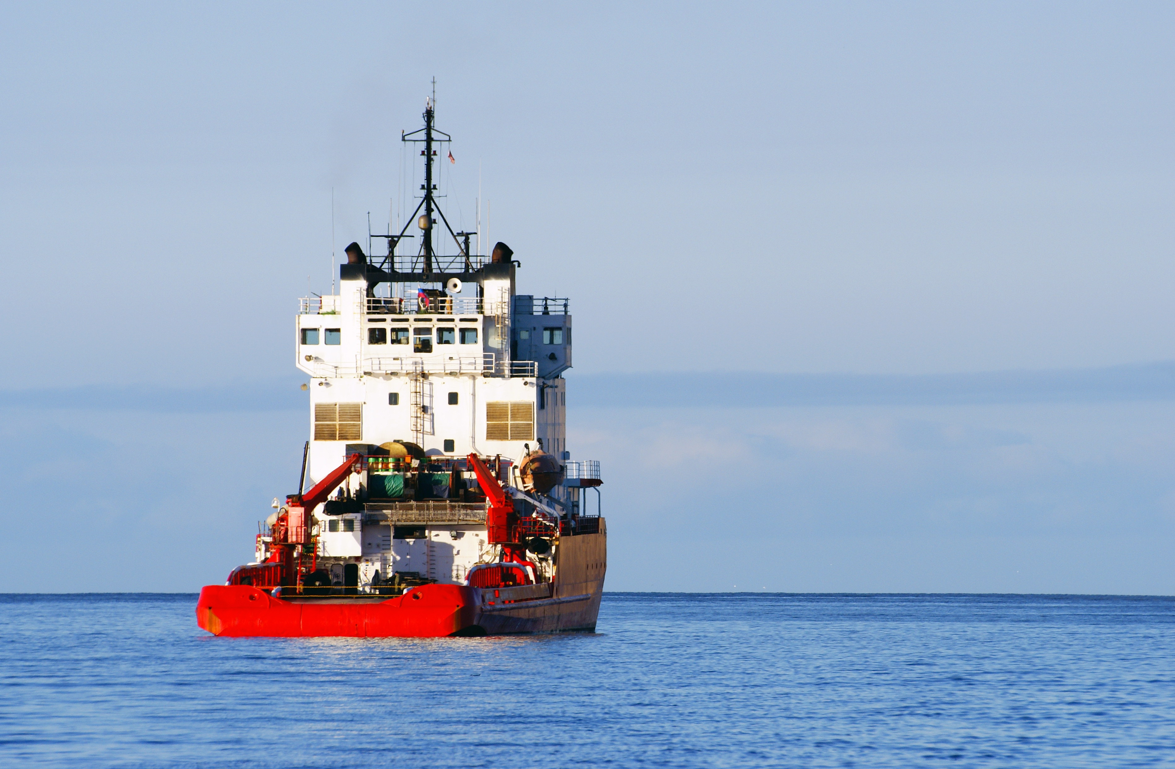 Large workboat sailing away in the distance