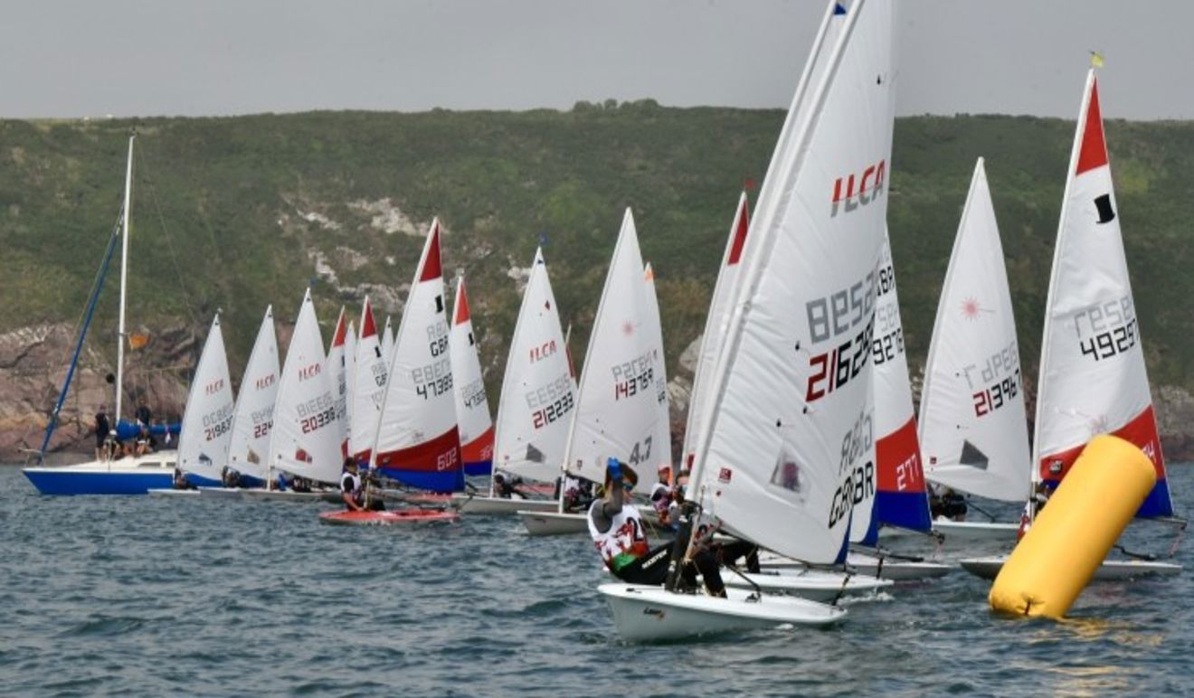 Topper and ILCA sailors coming off the start line at the Welsh Regional Junior Championships 2025.
