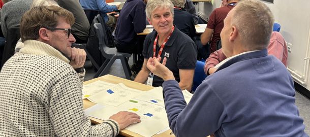 Mid shot of five Connected Conference attendees discussing an activity
