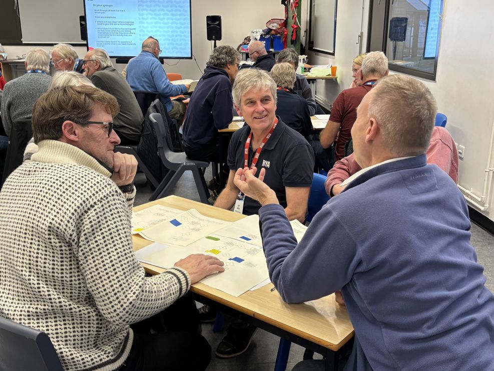 Mid shot of five Connected Conference attendees discussing an activity